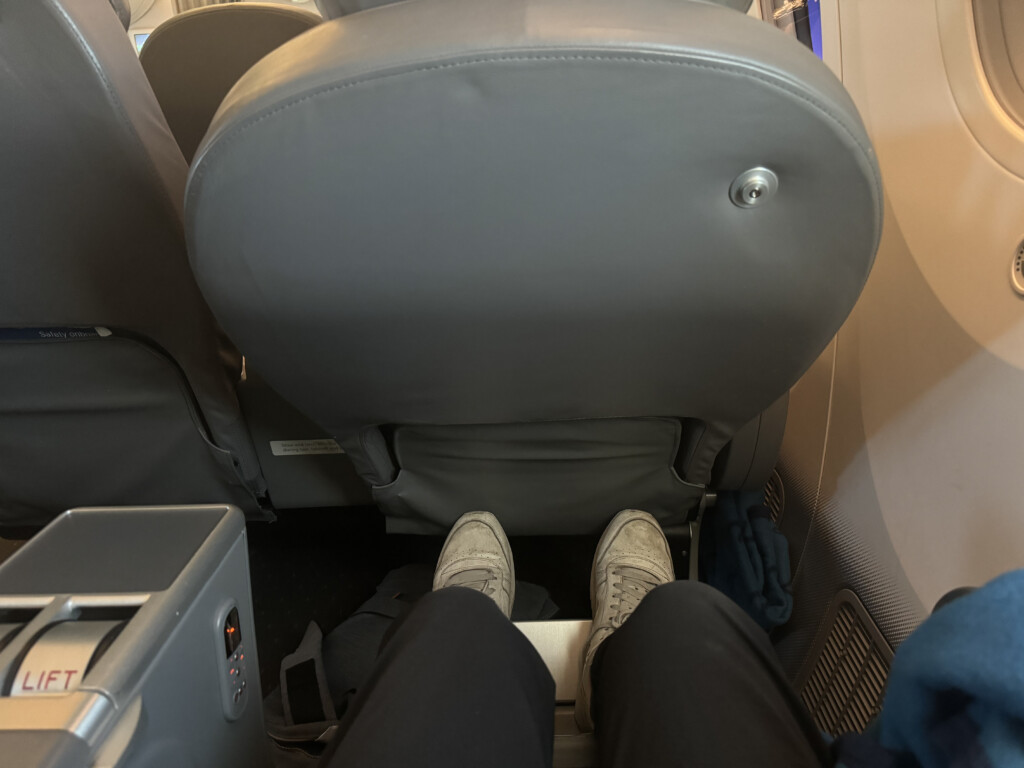 a person's legs in a grey seat