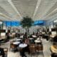 a group of people sitting at tables in a room with a tree