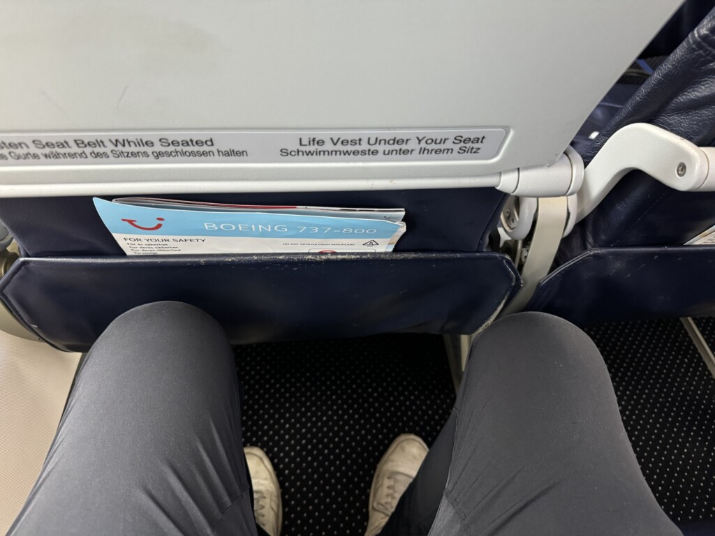 a person's legs and a sign on a plane