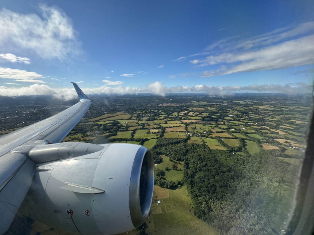 an airplane wing and engine above a landscape