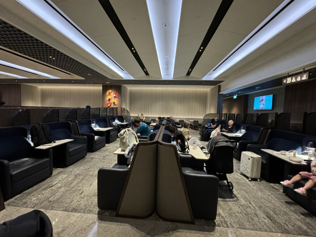 a group of people sitting at tables in a room with a screen