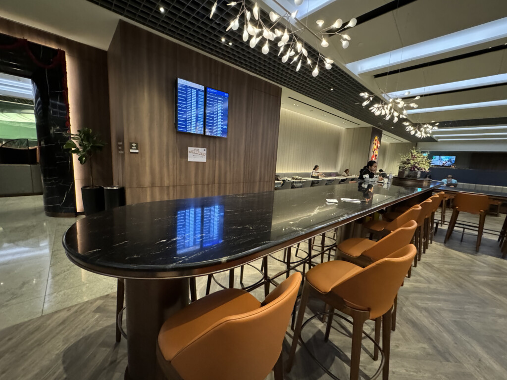 a long table with chairs in a room with a television on the wall