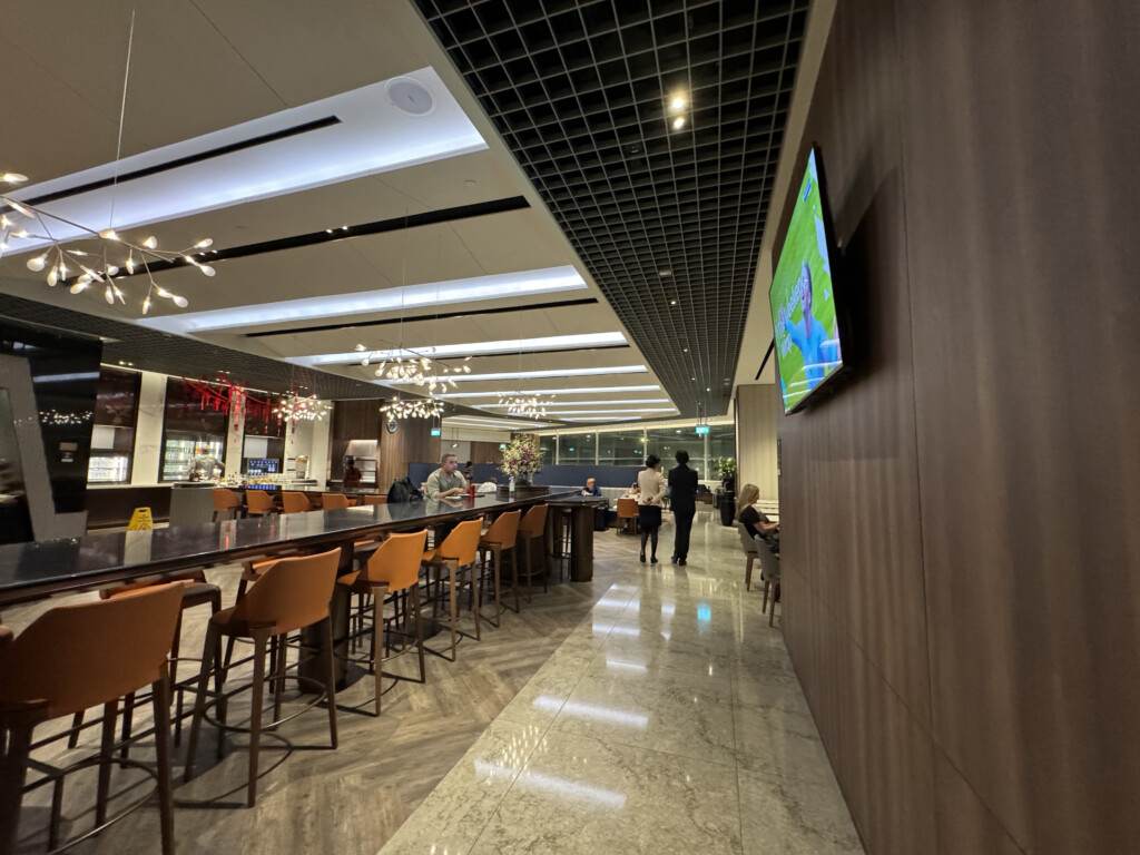 a long bar with chairs and a television