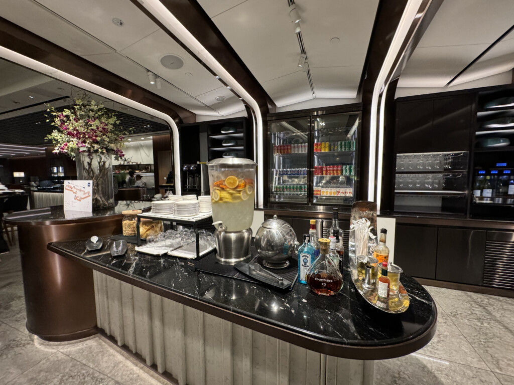 a counter with a drink dispenser and bottles on it