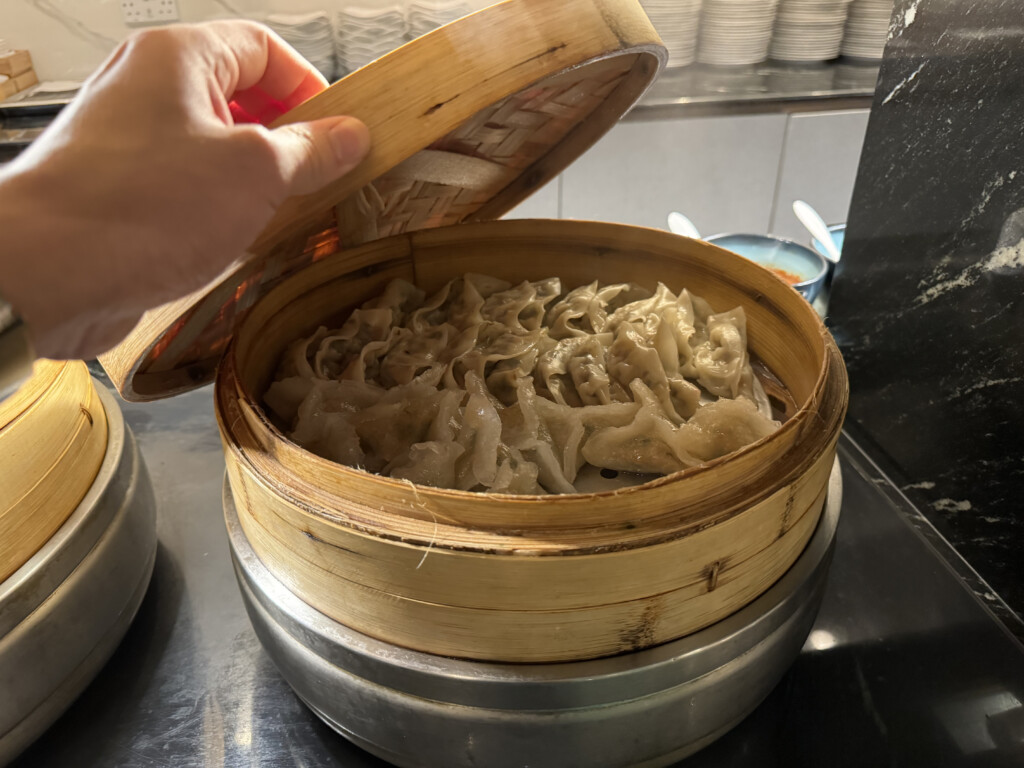 a person holding a steamer of food