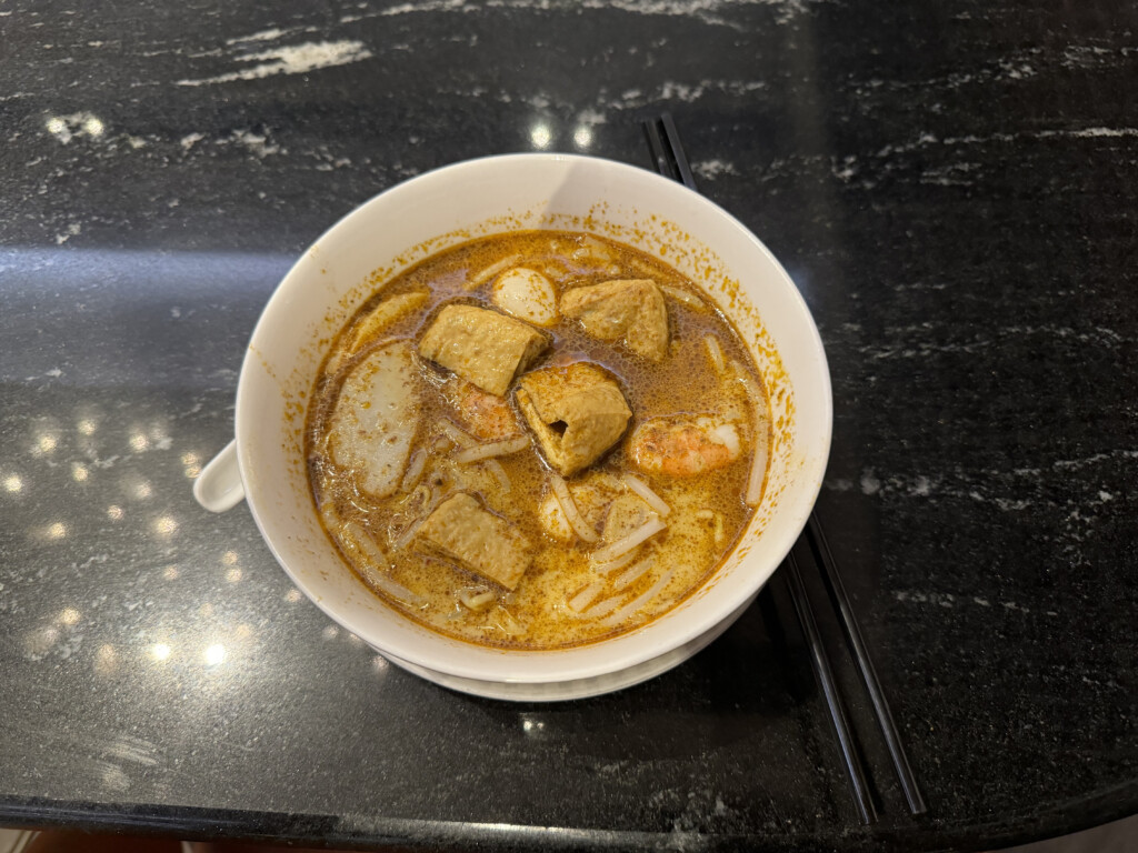 a bowl of soup with chopsticks