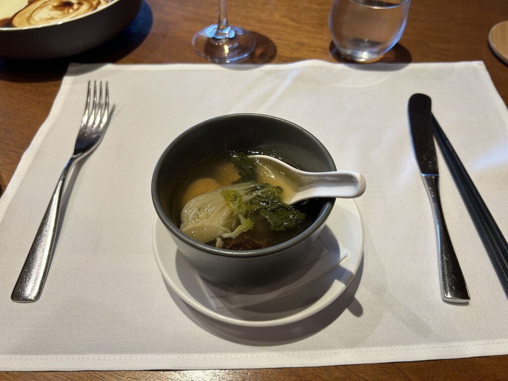 a bowl of soup on a plate with a spoon