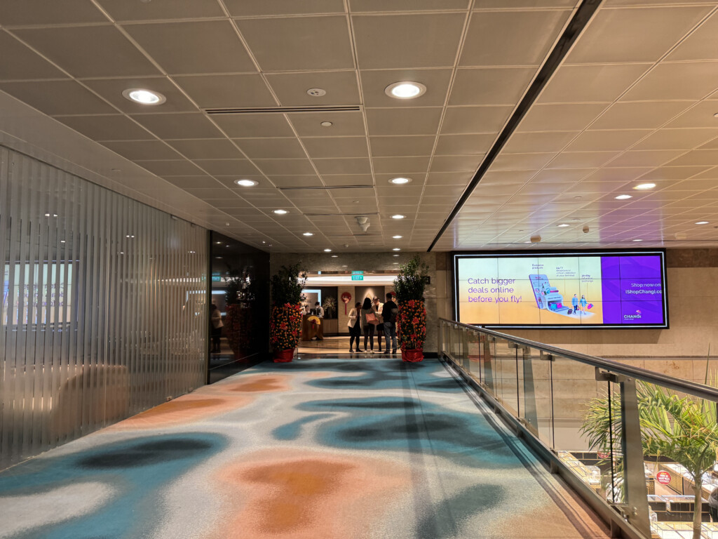 a hallway with a glass railing and a screen