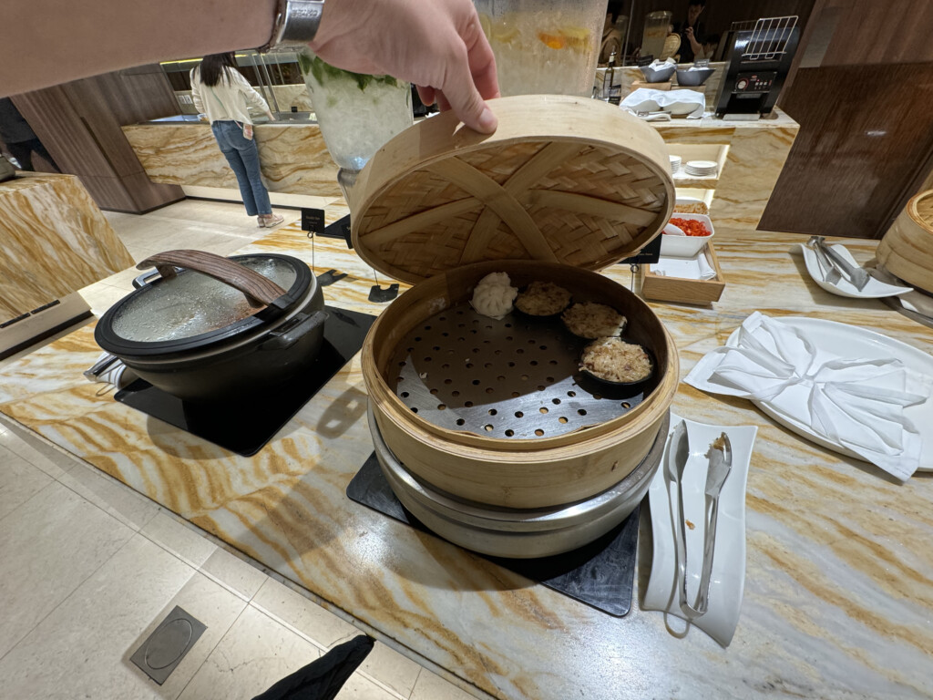 a person holding a steamer with food inside