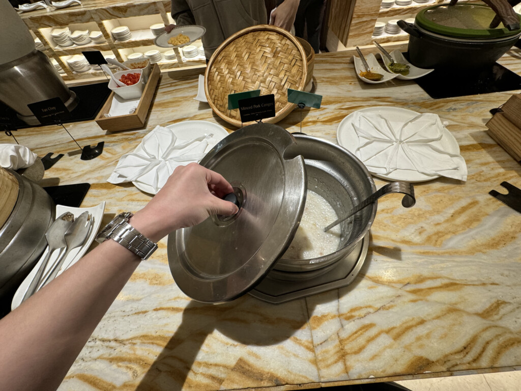 a person holding a lid over a pot of food