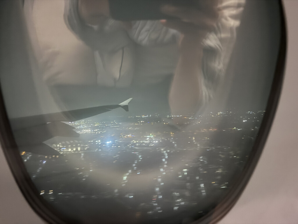 a reflection of a city in an airplane window