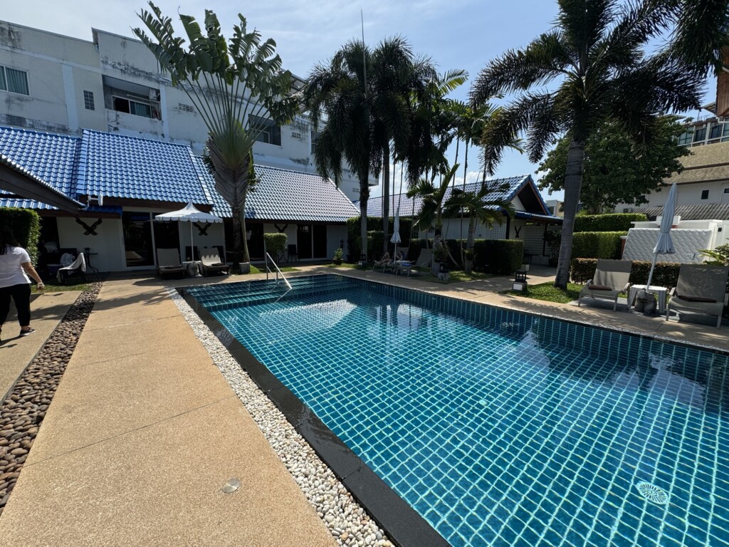 a pool with palm trees and buildings