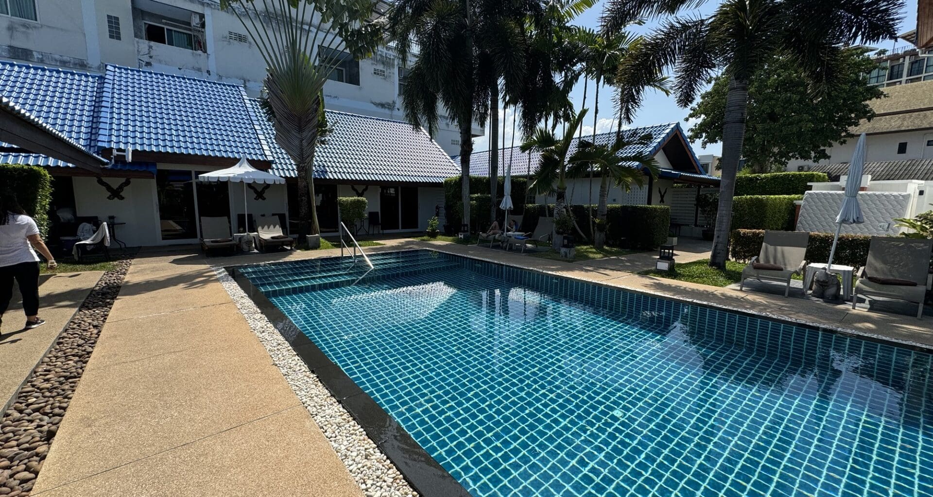 a pool with palm trees and buildings