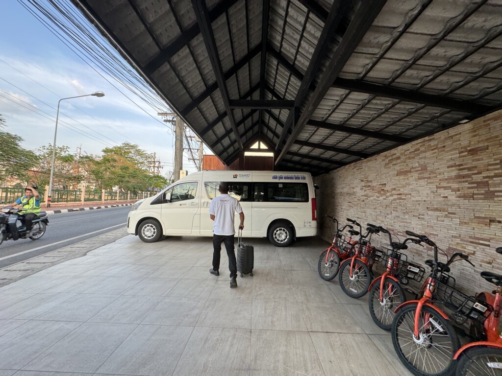 a man standing next to a van with a suitcase and bicycles