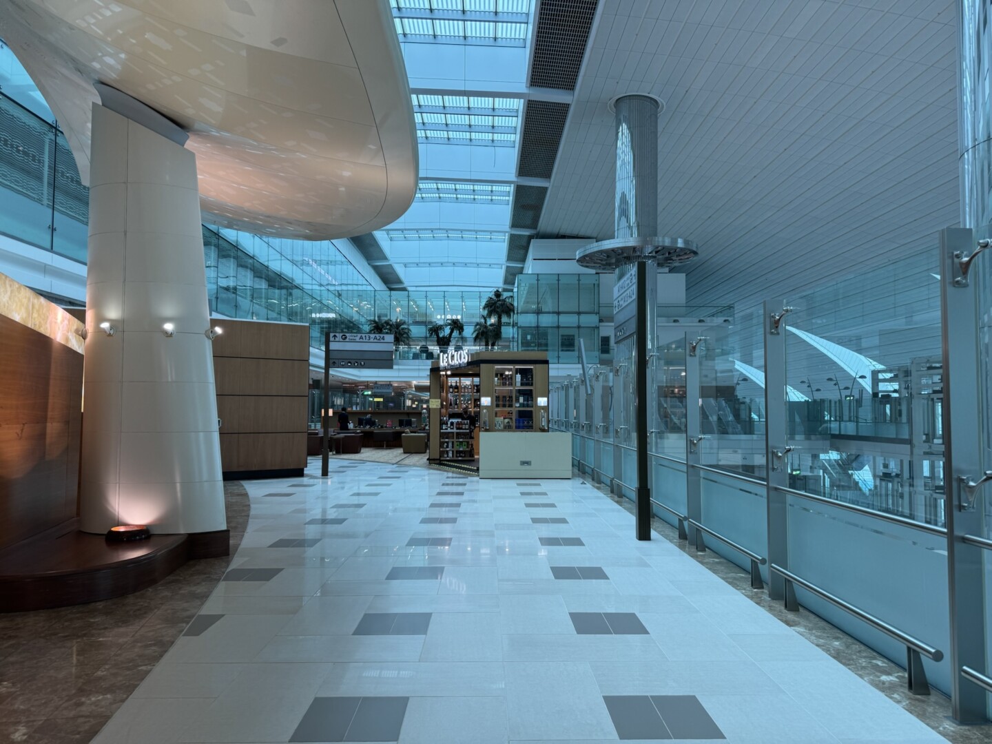 a hallway with glass walls and a shelf