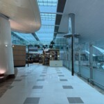 a hallway with glass walls and a shelf