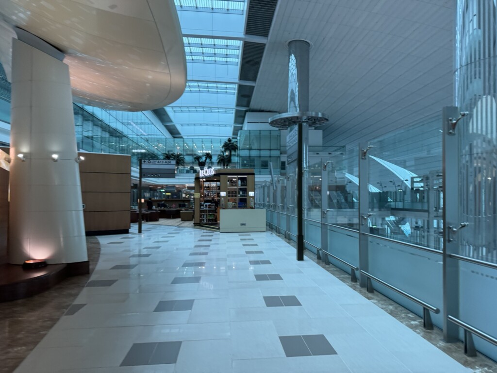 a hallway with glass walls and a shelf