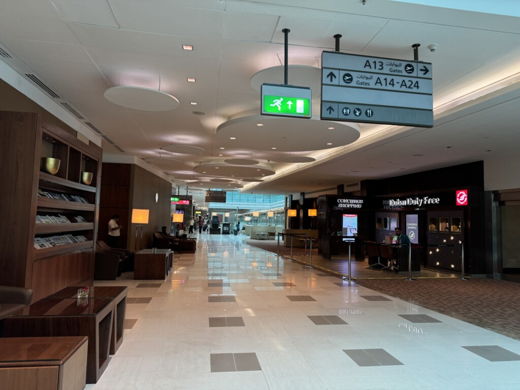a large airport terminal with signs and people walking