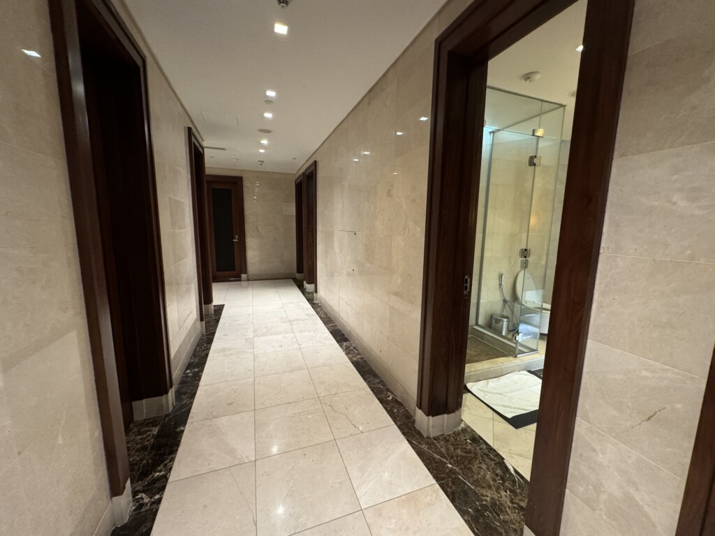 a hallway with marble walls and a shower