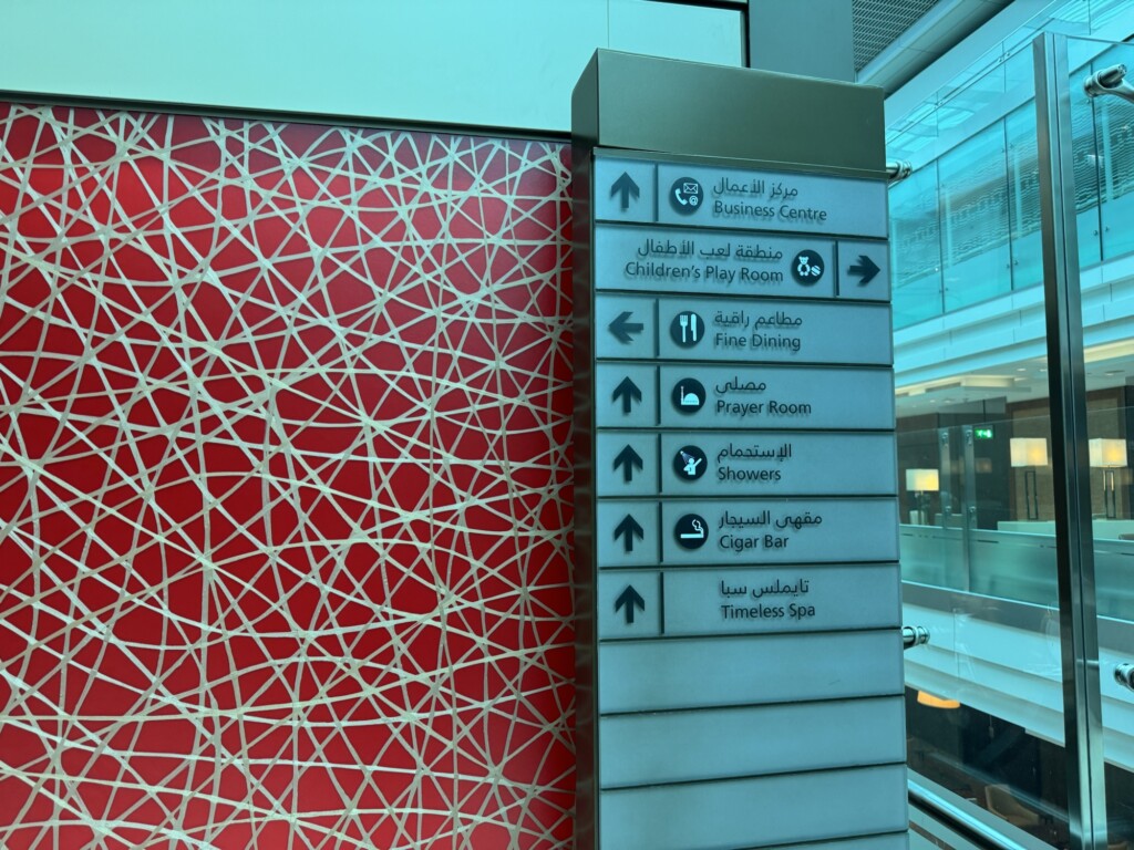 a sign with arrows and red wall
