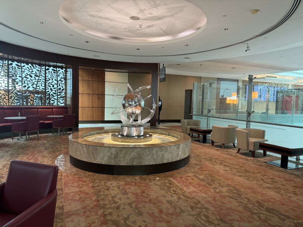 a large circular fountain in a room with chairs and a large ceiling