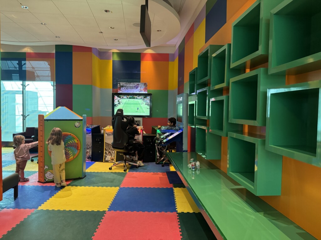a room with colorful walls and a playroom with a game machine and a child