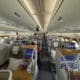 inside an airplane with seats and people sitting on it