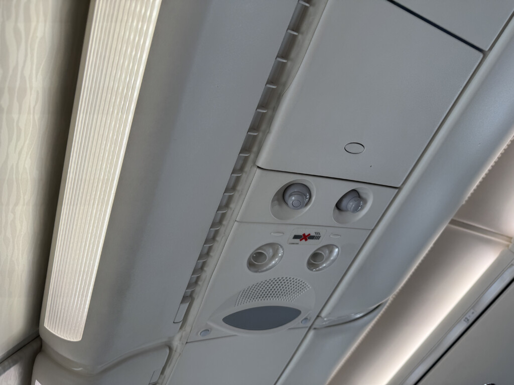 a white panel with buttons and a light on the ceiling