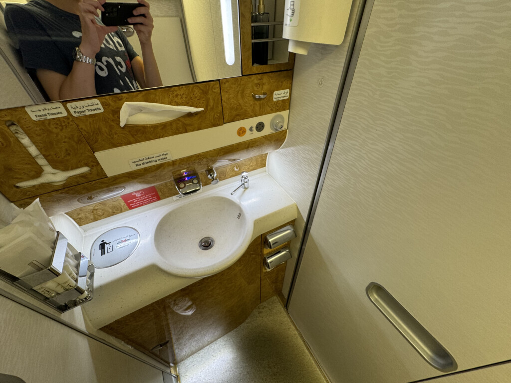 a person taking a picture of a sink in a bathroom