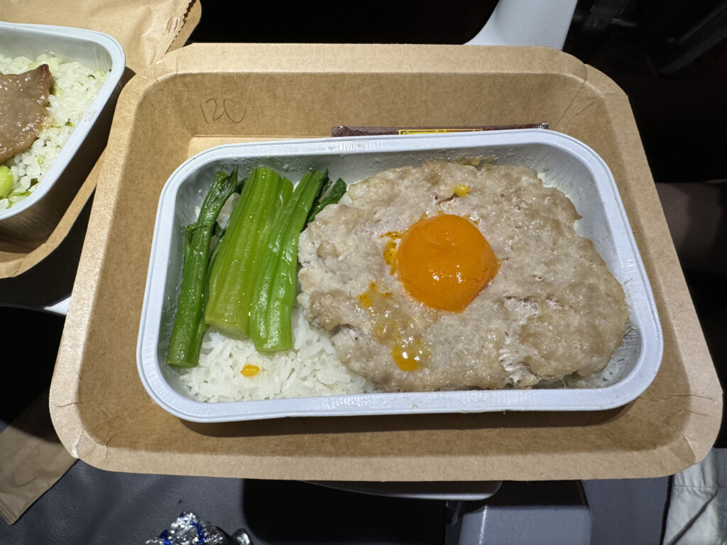 a tray of food with a egg yolk and rice