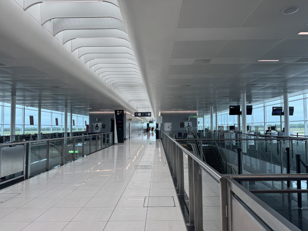 a white hallway with glass walls and railings