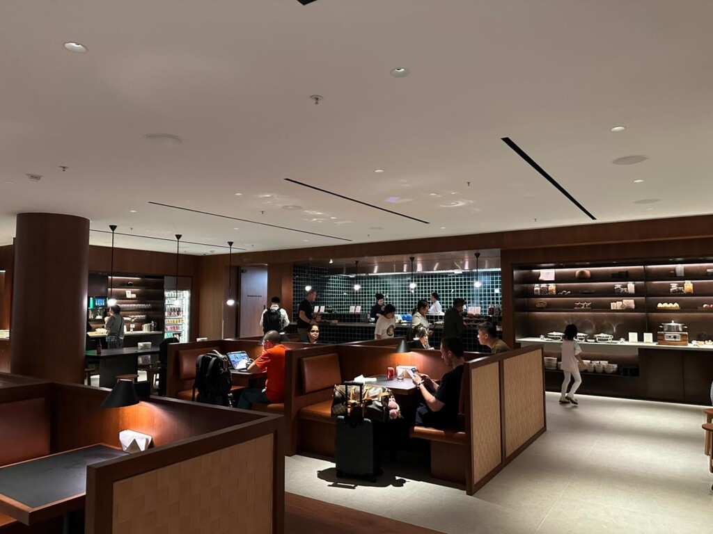 a room with many people sitting at tables and chairs
