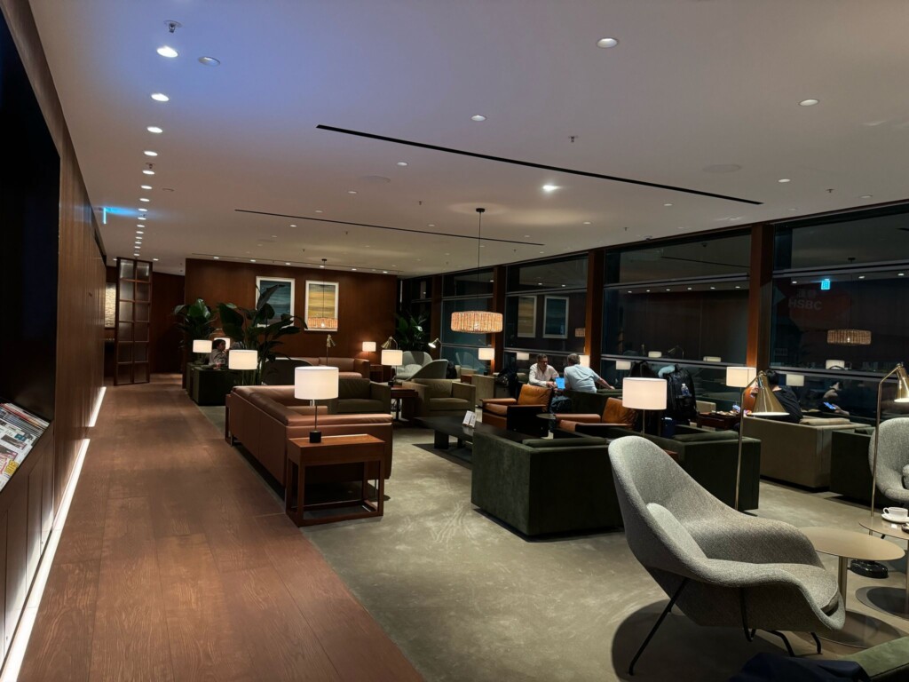a room with a large window and a large couch and chairs