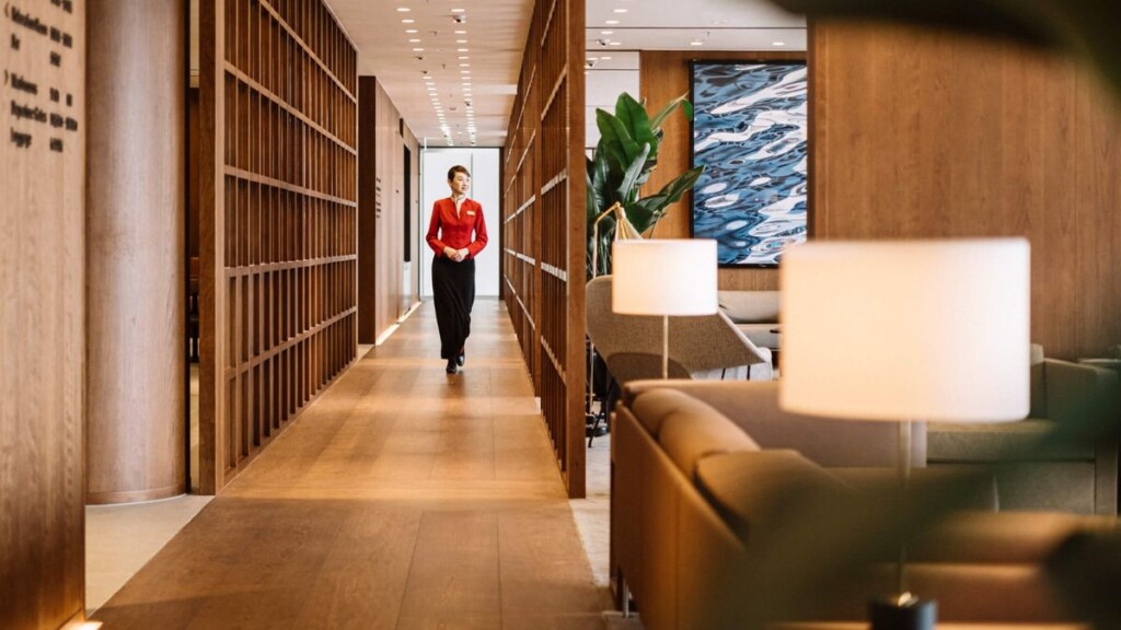 a woman in a red shirt walking down a hallway