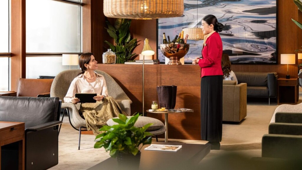 a woman in a red jacket talking to a woman in a room