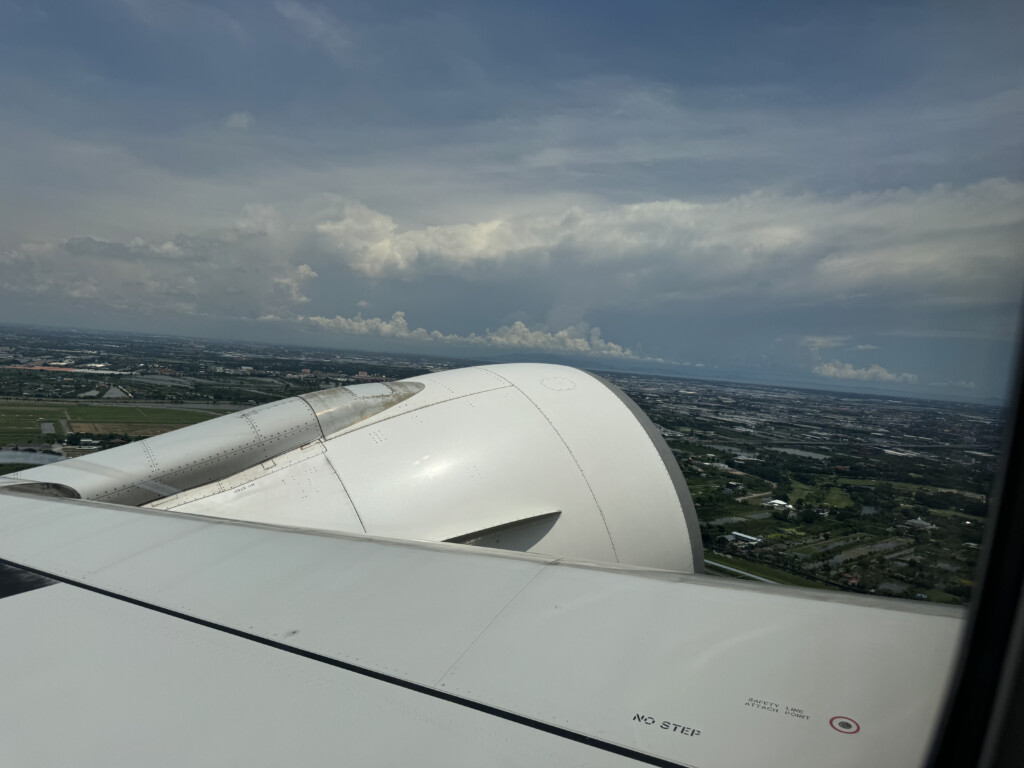 an airplane wing with a city in the background