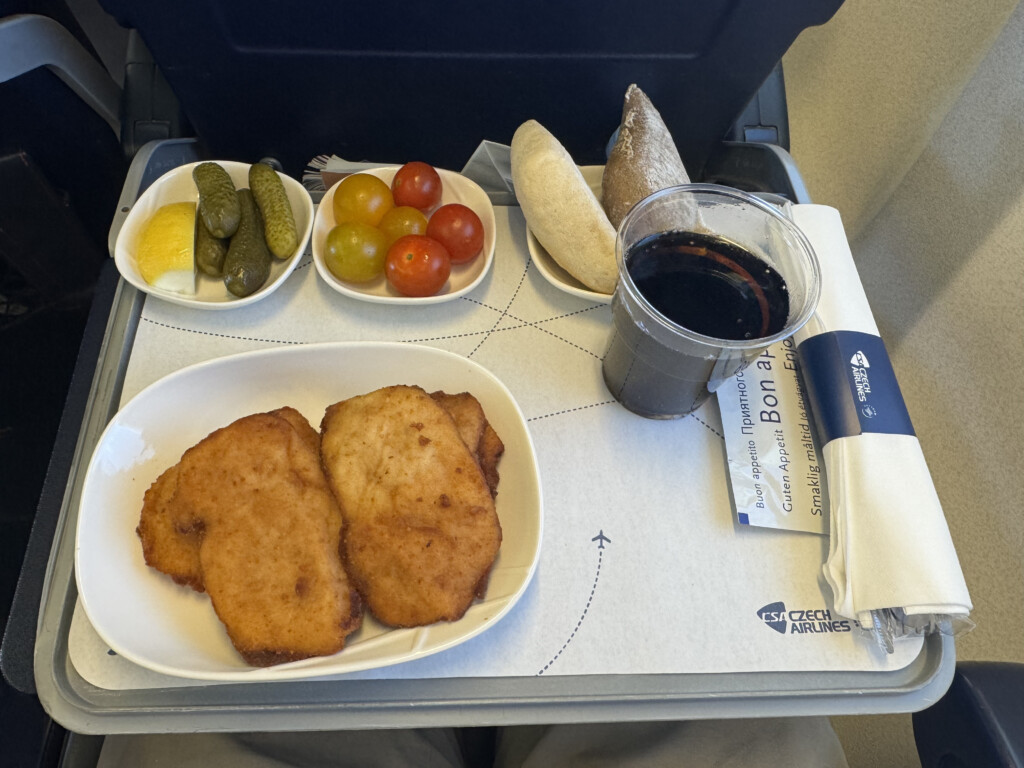 food on a tray with a drink and a plate of food