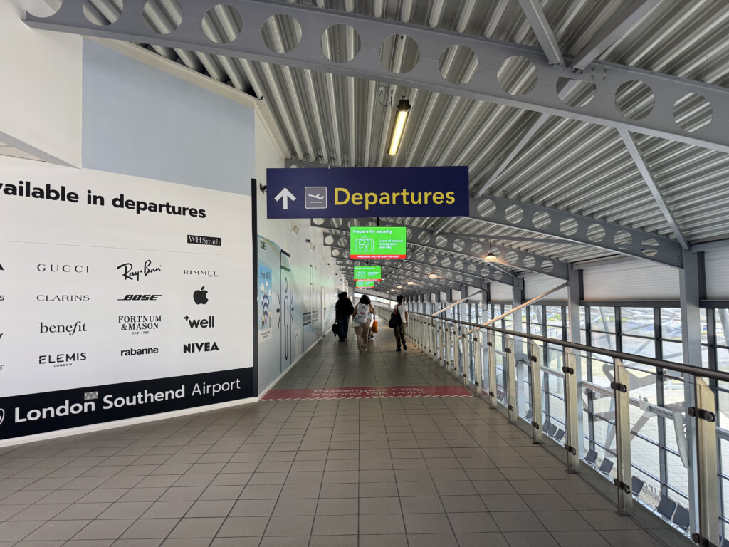 a walkway with signs and people walking