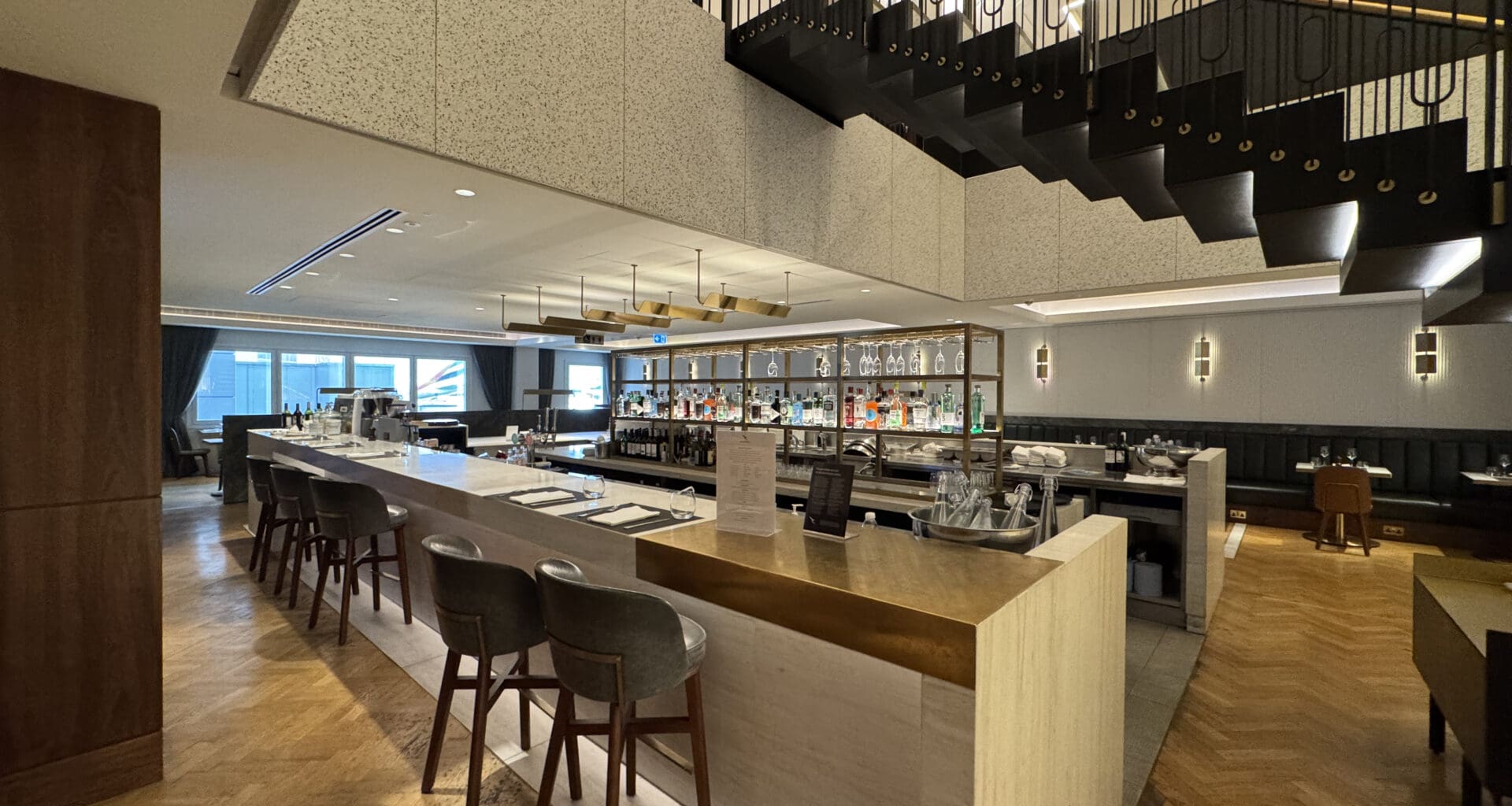 a bar with chairs and a staircase