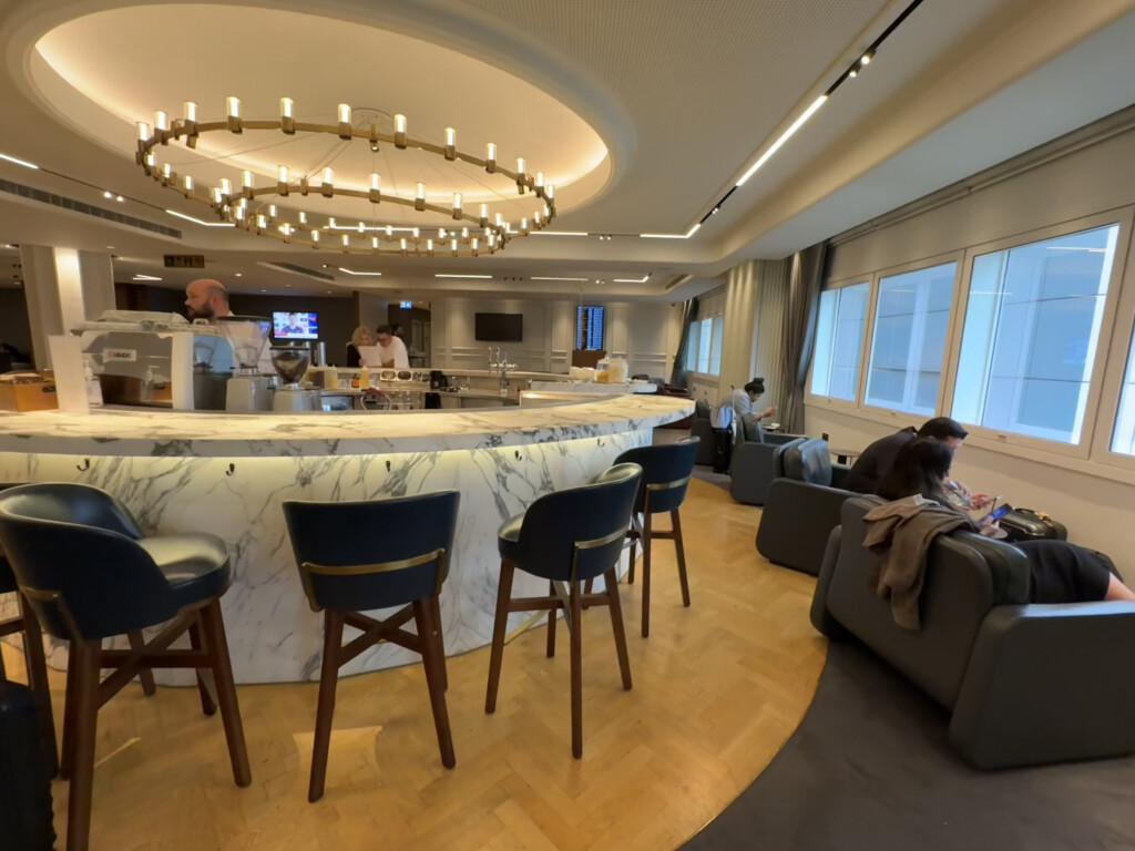 a room with a marble counter and chairs