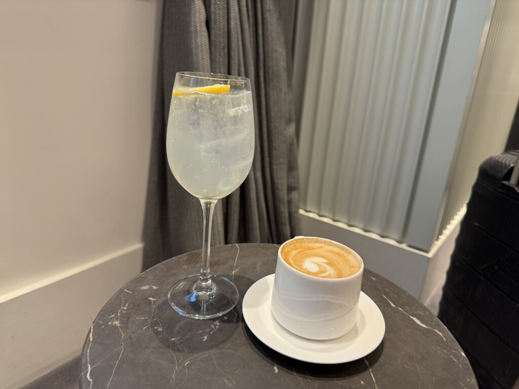 a glass of liquid and a cup of coffee on a table