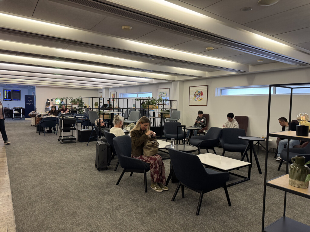 people sitting in a room with tables and chairs
