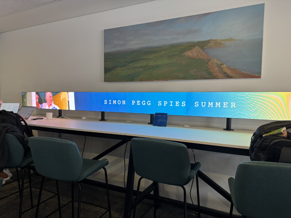 a desk with chairs and a large screen