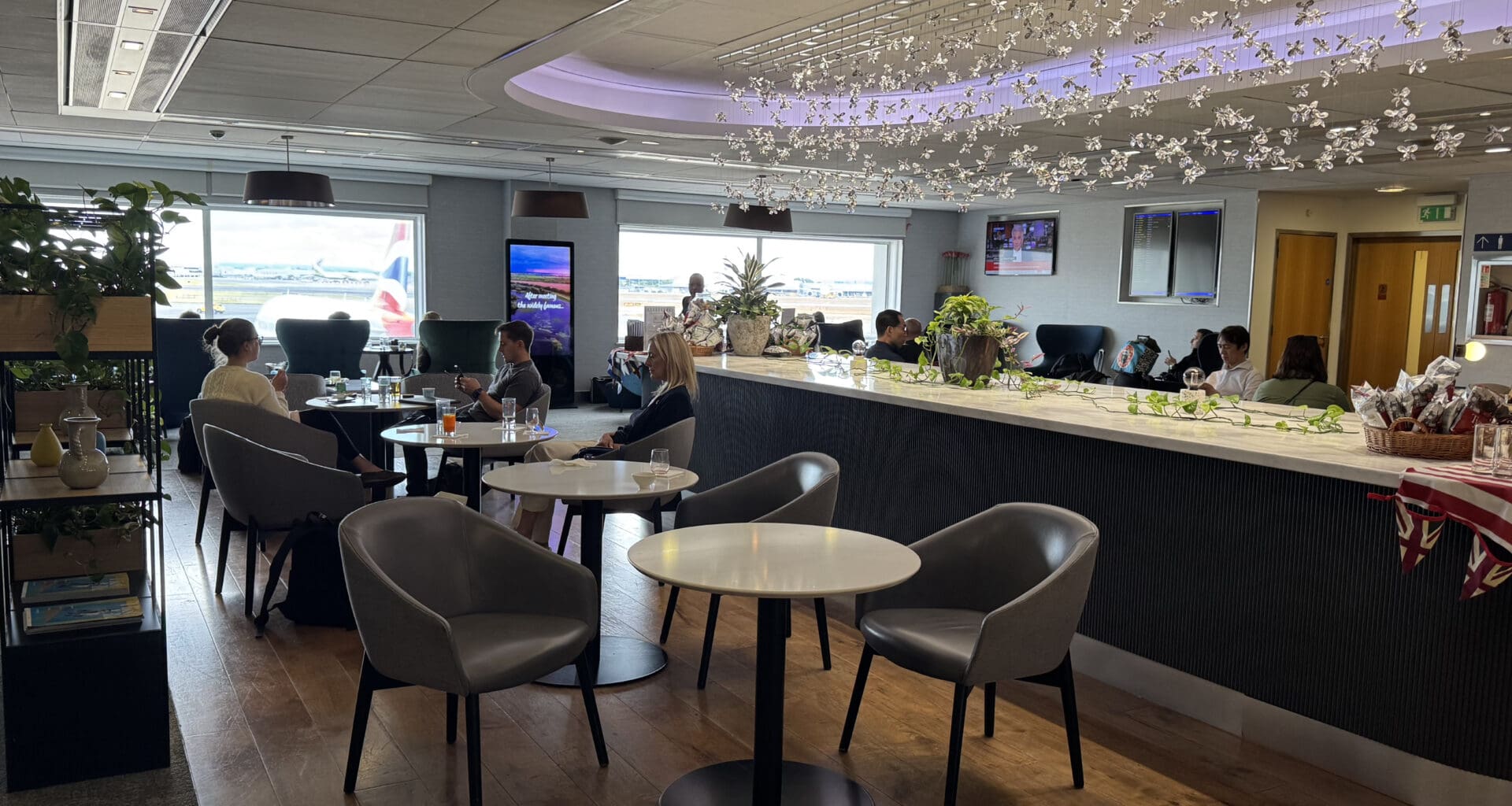 a group of people sitting at tables in a room with a large window