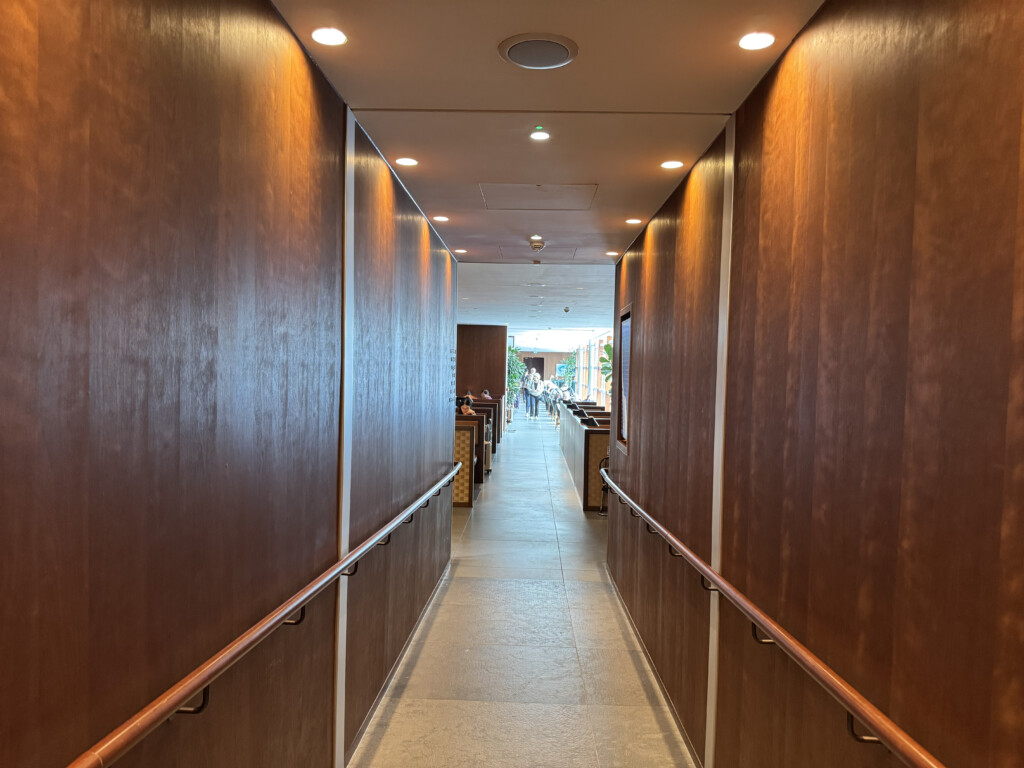 a hallway with a railing and wood walls