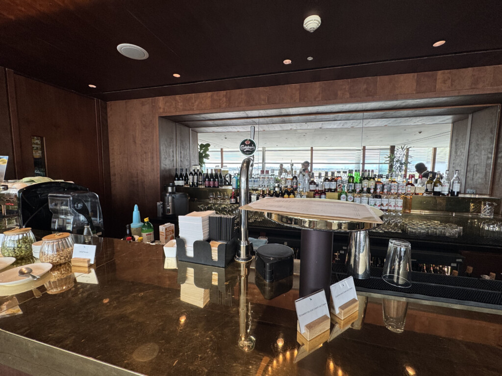 a bar with a counter and bottles of alcohol