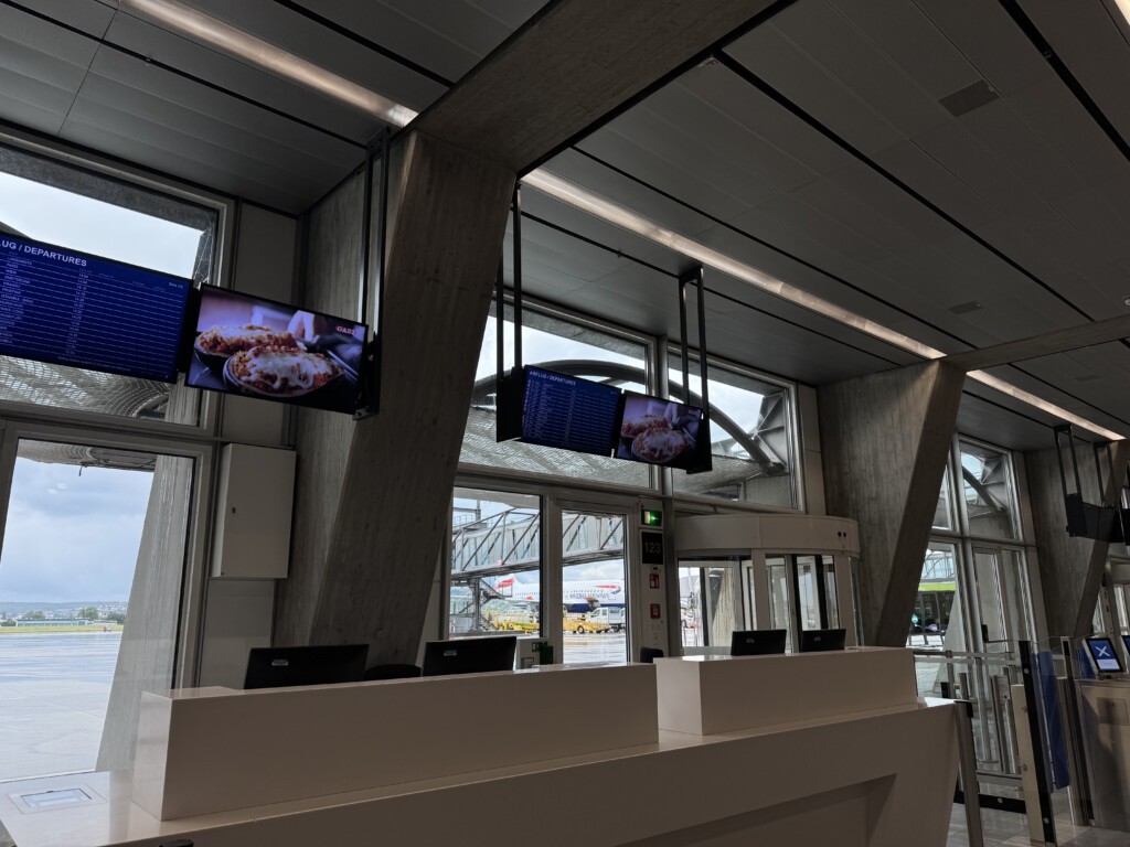 a reception desk with a screen from the ceiling