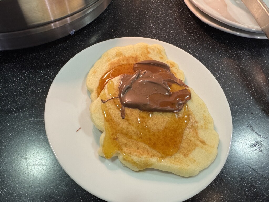 a plate of pancakes with chocolate spread on top