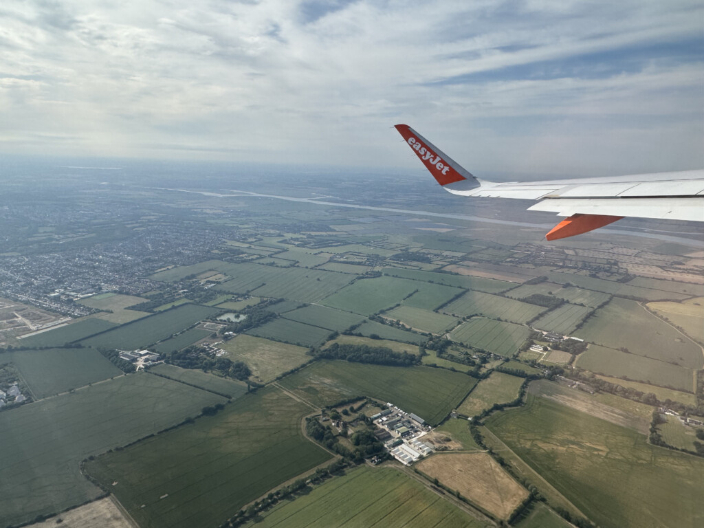 an airplane wing above a landscape