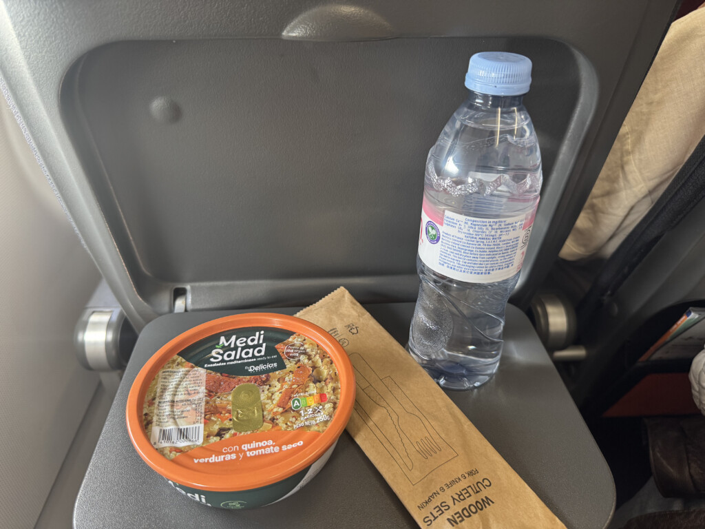 a bowl of food and a bottle of water on a chair
